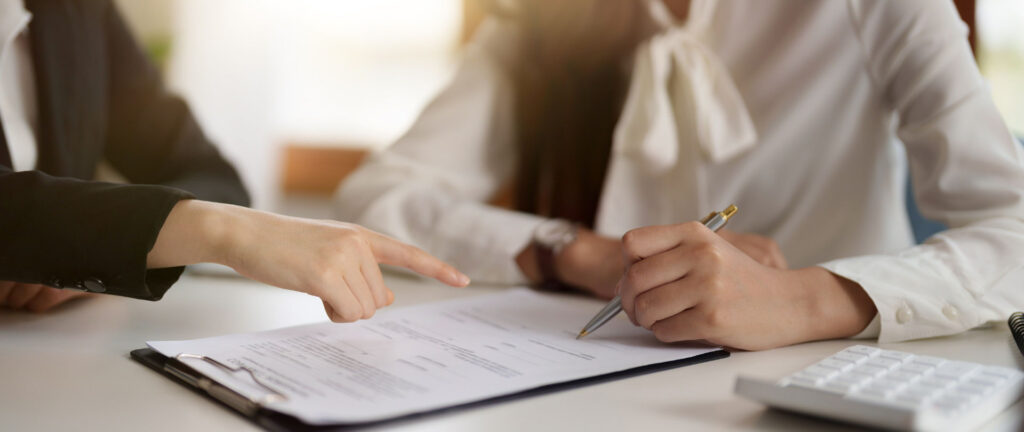 A real estate agent and client collaborating on important documents, ensuring a smooth and transparent transaction.